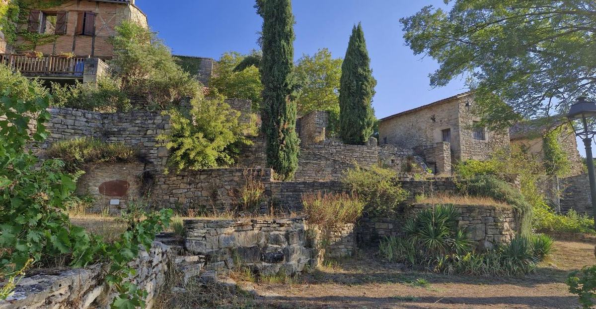 Vue du vieux village depuis la place de l'EMAC : château, maisons et terrasses étagées